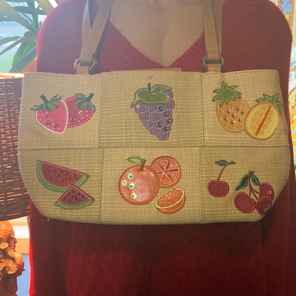No brand cute basket purse with straps and colorful fruit patches on front.